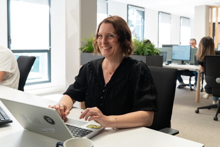 Portrait chaleureux d'une collaboratrice Fit Retail au bureau
