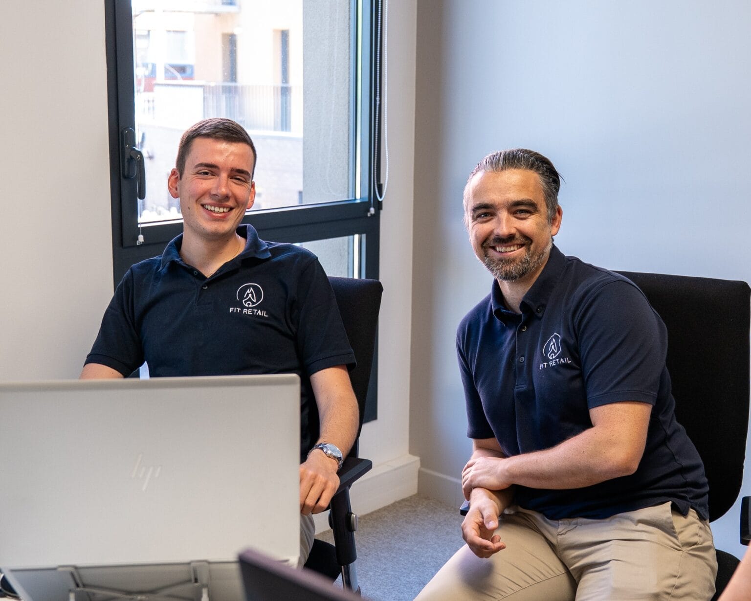 Deux collaborateurs Fit Retail souriants en pause bureau