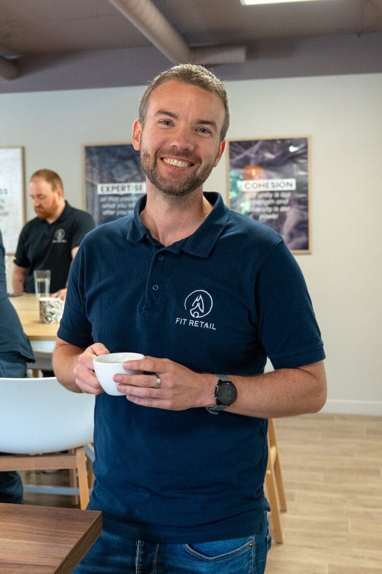 Collaborateur Fit Retail souriant, pause café au bureau