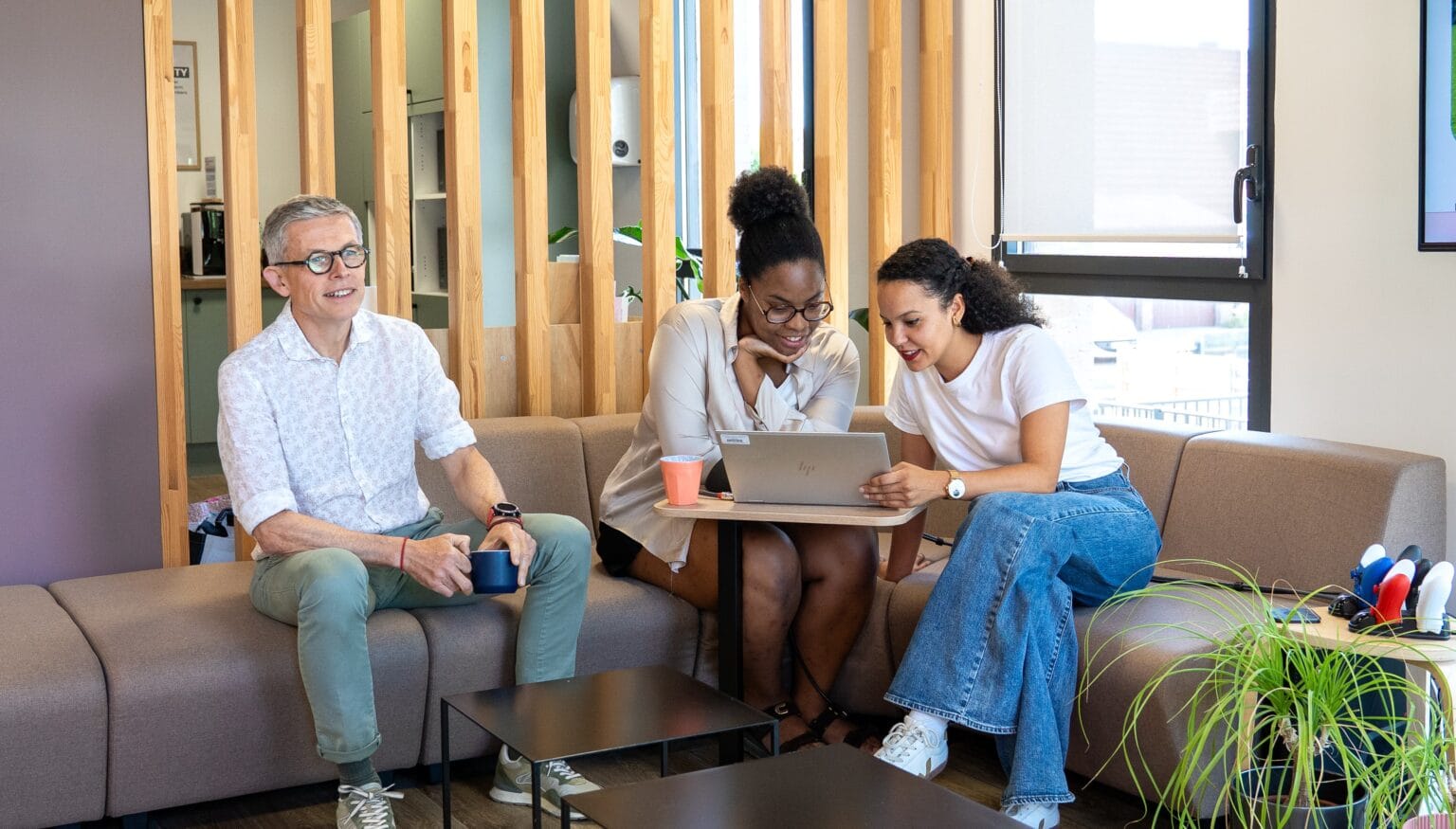 Trois collaborateurs Fit Retail échangeant autour d'un ordinateur portable
